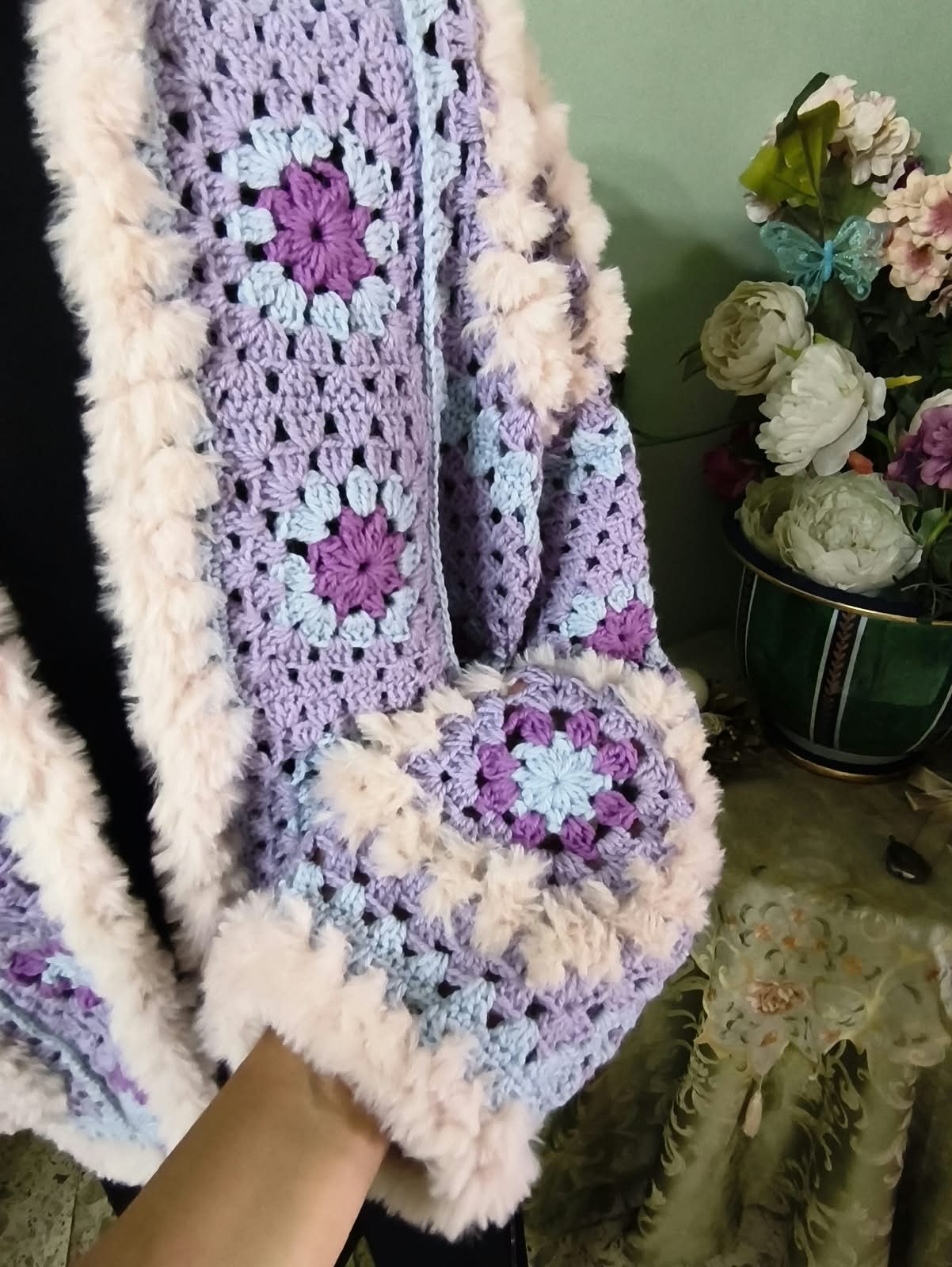 Manica del cardigan lilla, lavorazione tenuta in mano